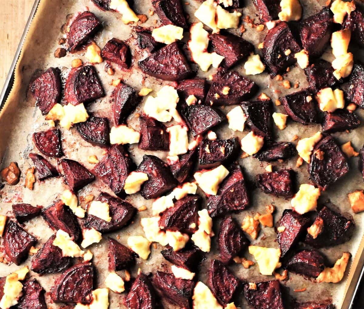 Roasted beet wedges and crumbled feta on baking sheet.