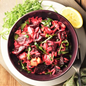 Top down view of beet and feta salad in purple bowl.