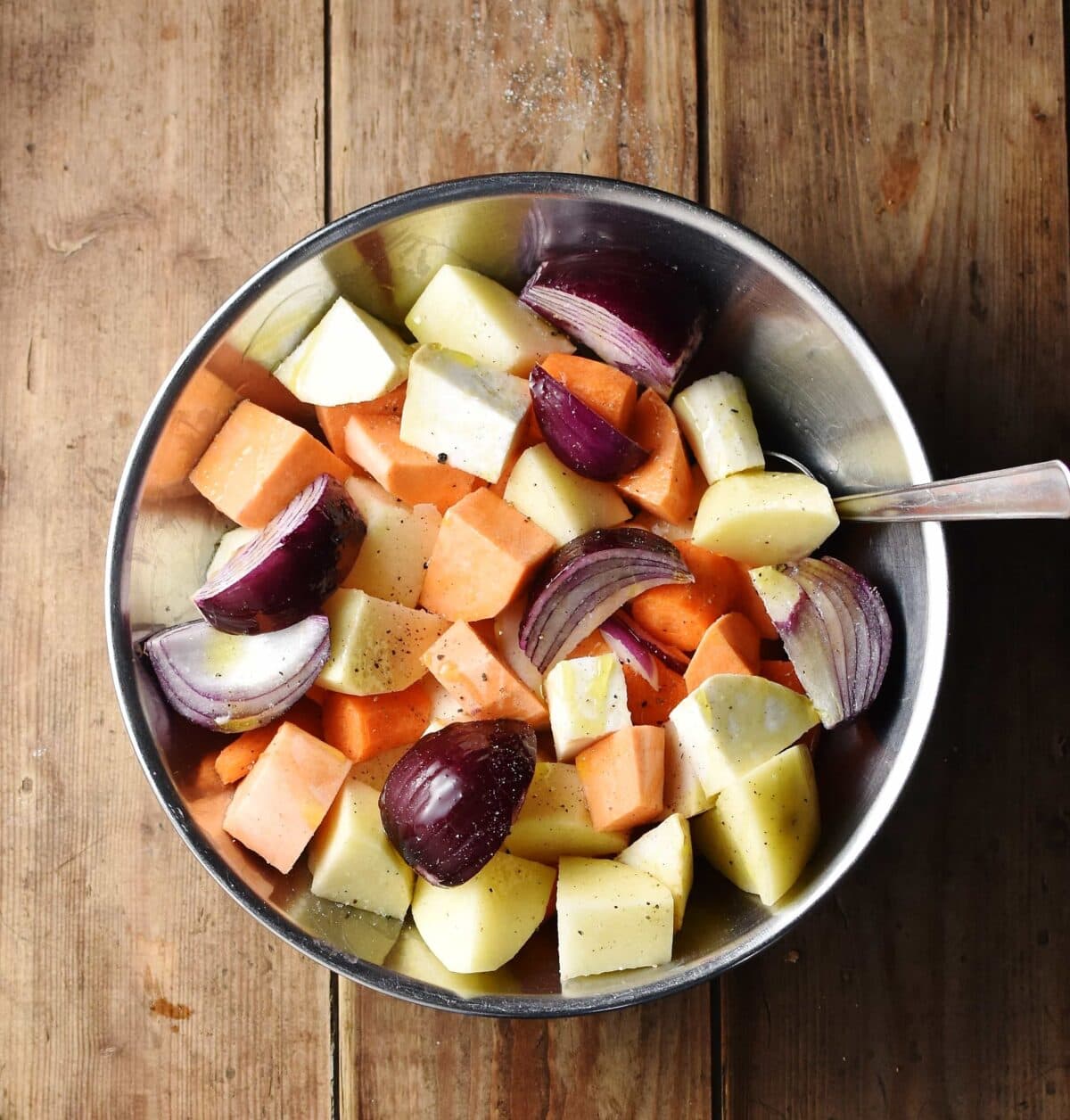 Chunks of peeled root vegetables and red onion.