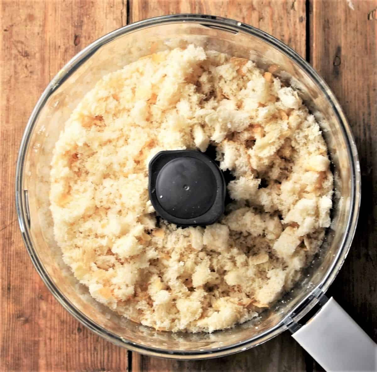 Coarse bread pieces in food processor bowl.