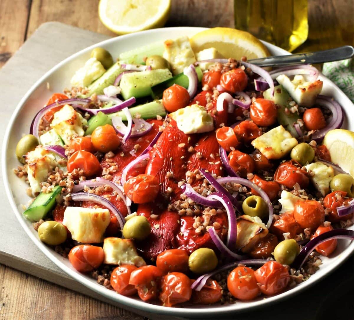 Buckwheat salad with roasted vegetables and feta on large plate.