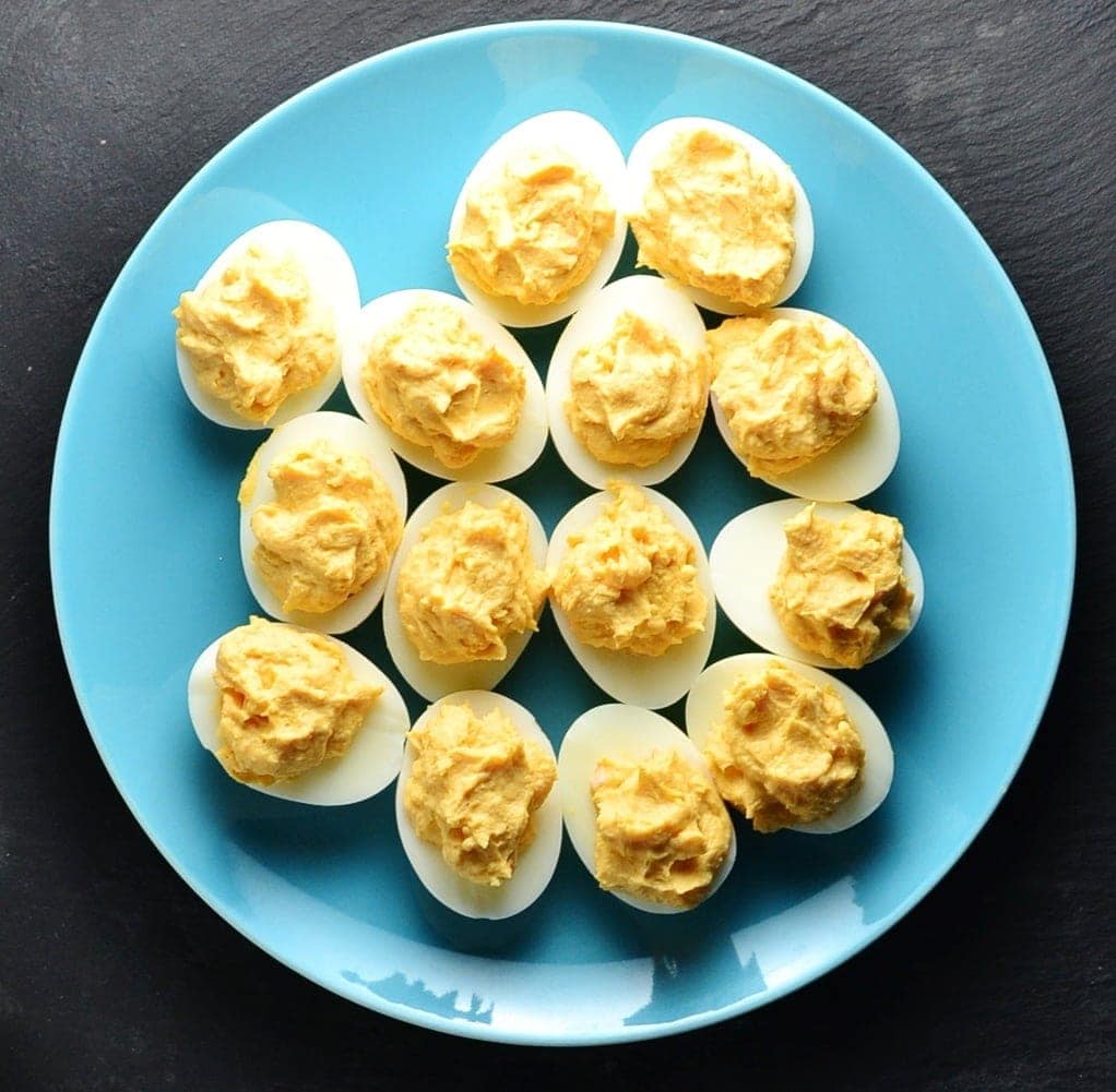  Top down view of deviled eggs on blue plate.