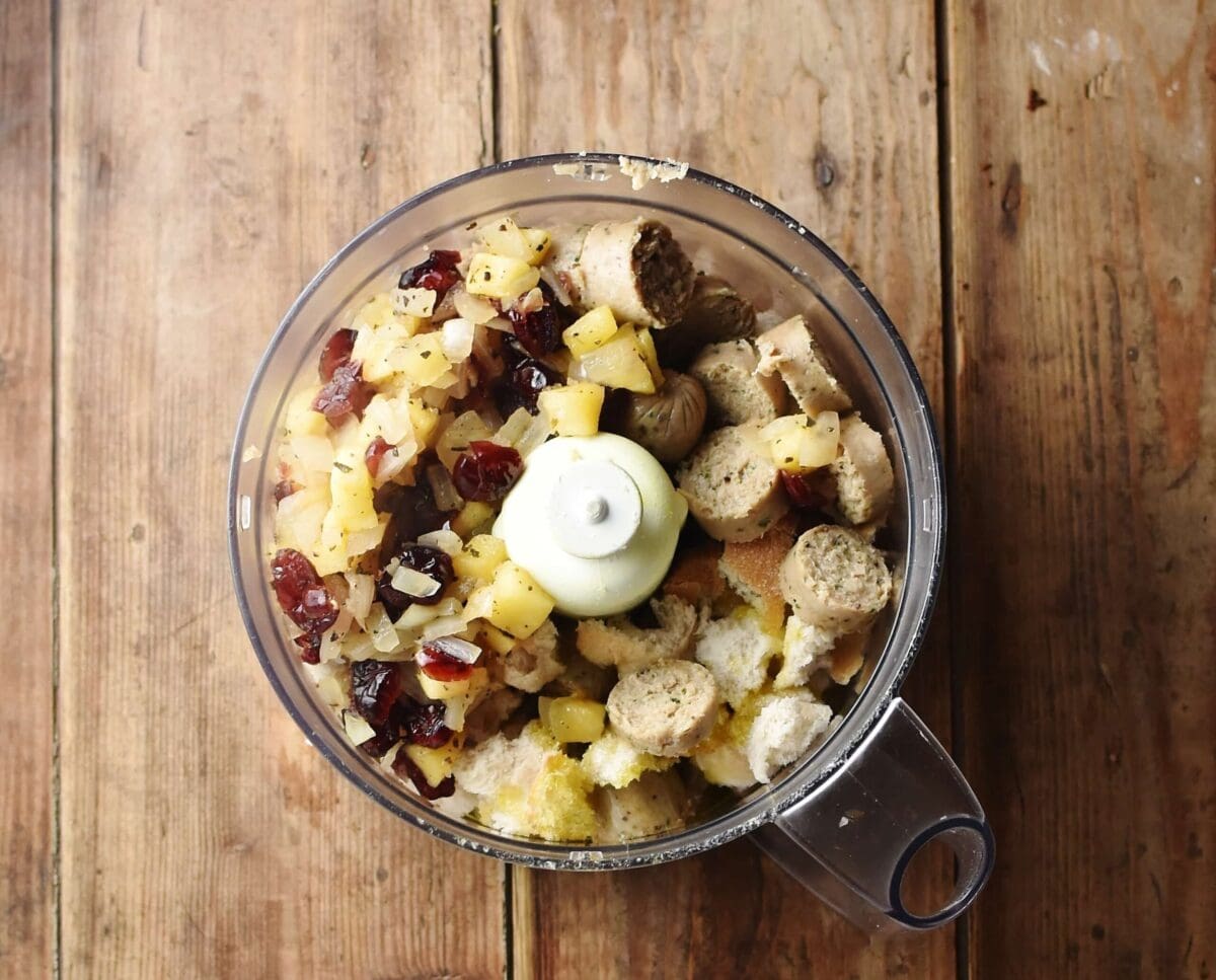 Chopped sausage, cranberries, apple and bread pieces in blender.