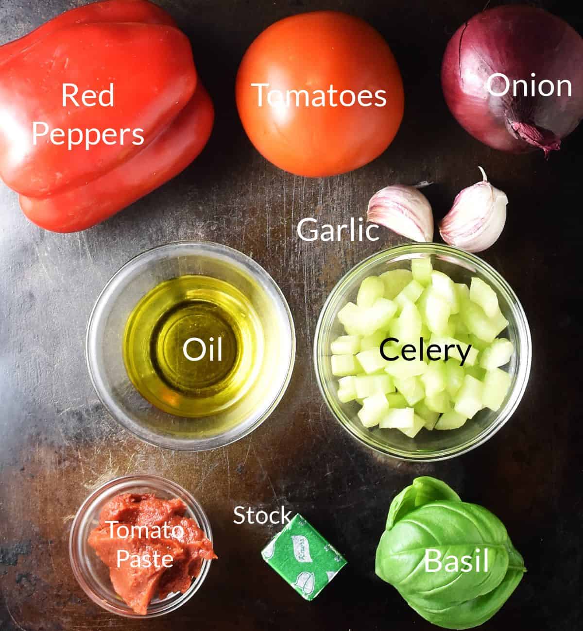 Top down view of ingredients in individual dishes for making red pepper tomato soup.