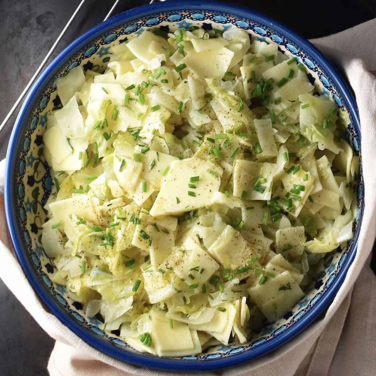 Top down view of Polish cabbage pasta in blue bowl.