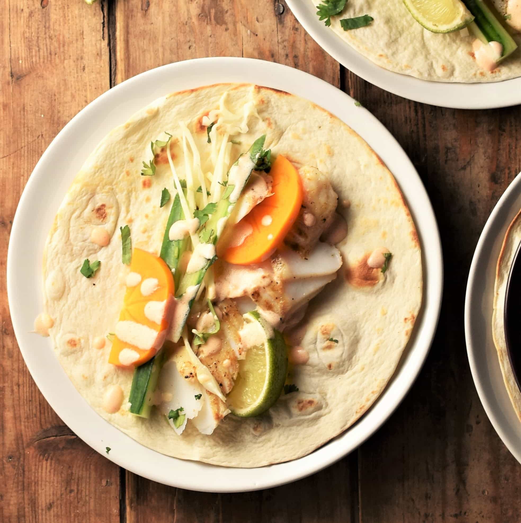 Open fish wrap on top of white plate.
