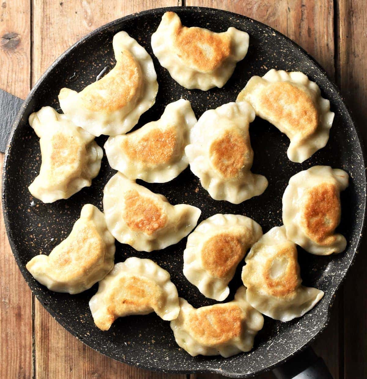 Fried pierogi in large pan.