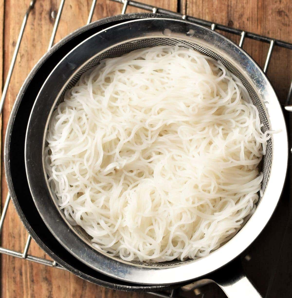 Cooked noodles in strainer.