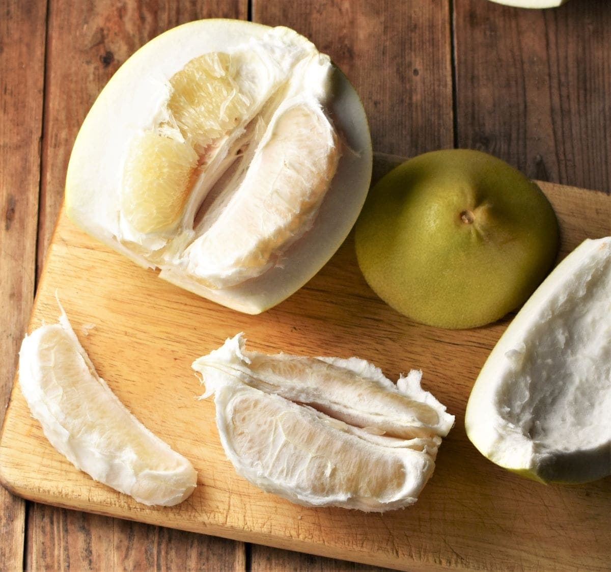 Peeling pomelo on top of cutting board.