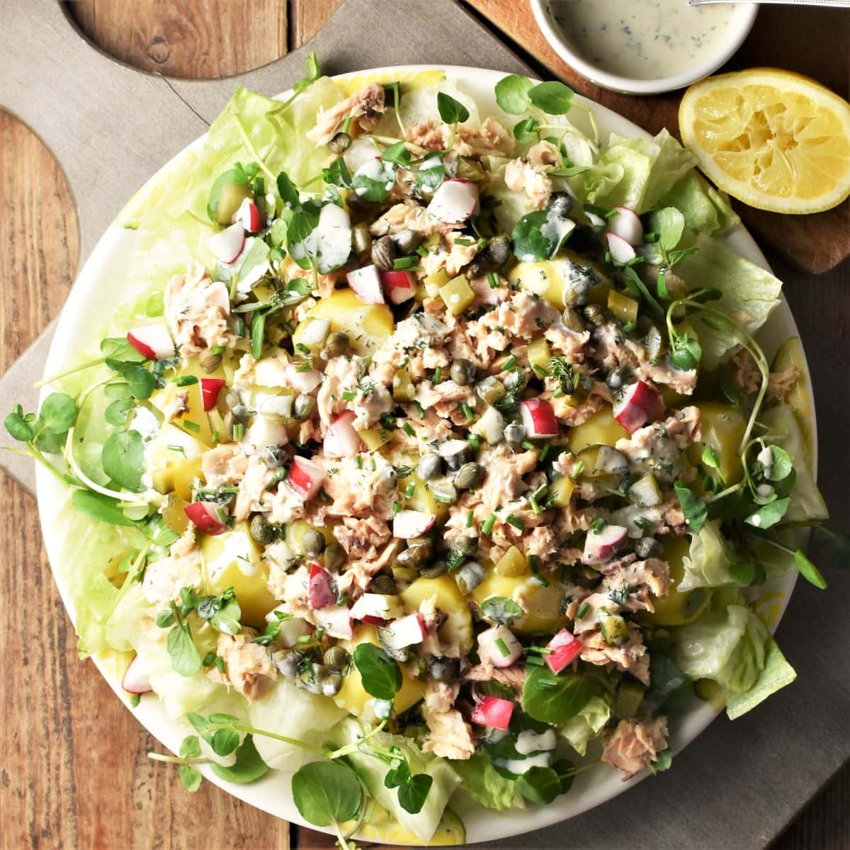 Canned salmon salad with potatoes and vegetables on large plate.