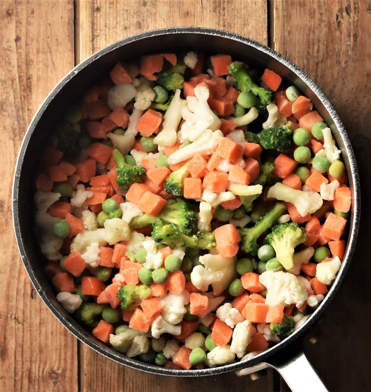 Frozen vegetables inside soup pot.