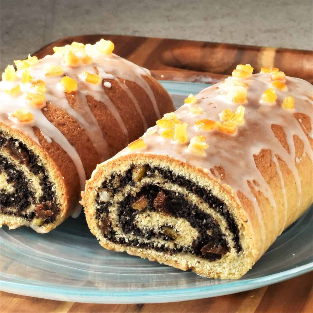 Side view of Polish poppy seed cake cut in half on top of blue plate.