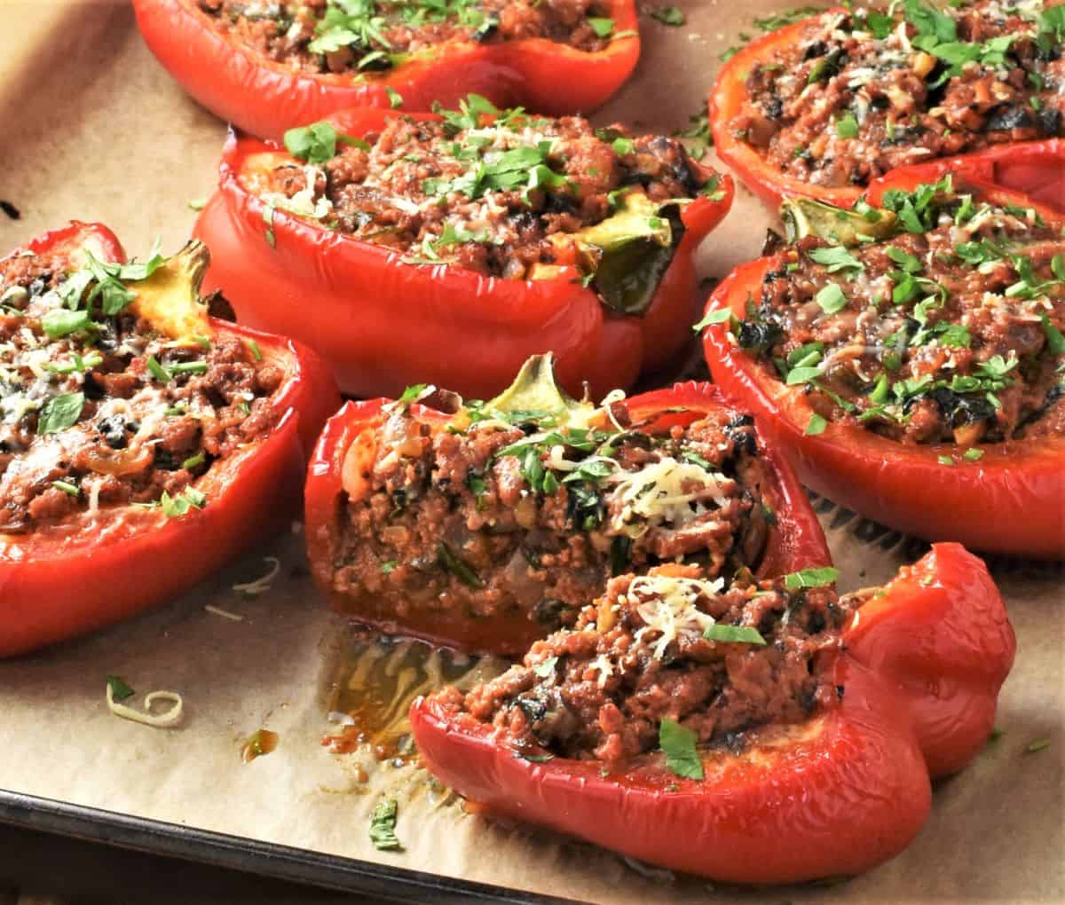 Side view of no-rice stuffed red peppers on top of parchment.