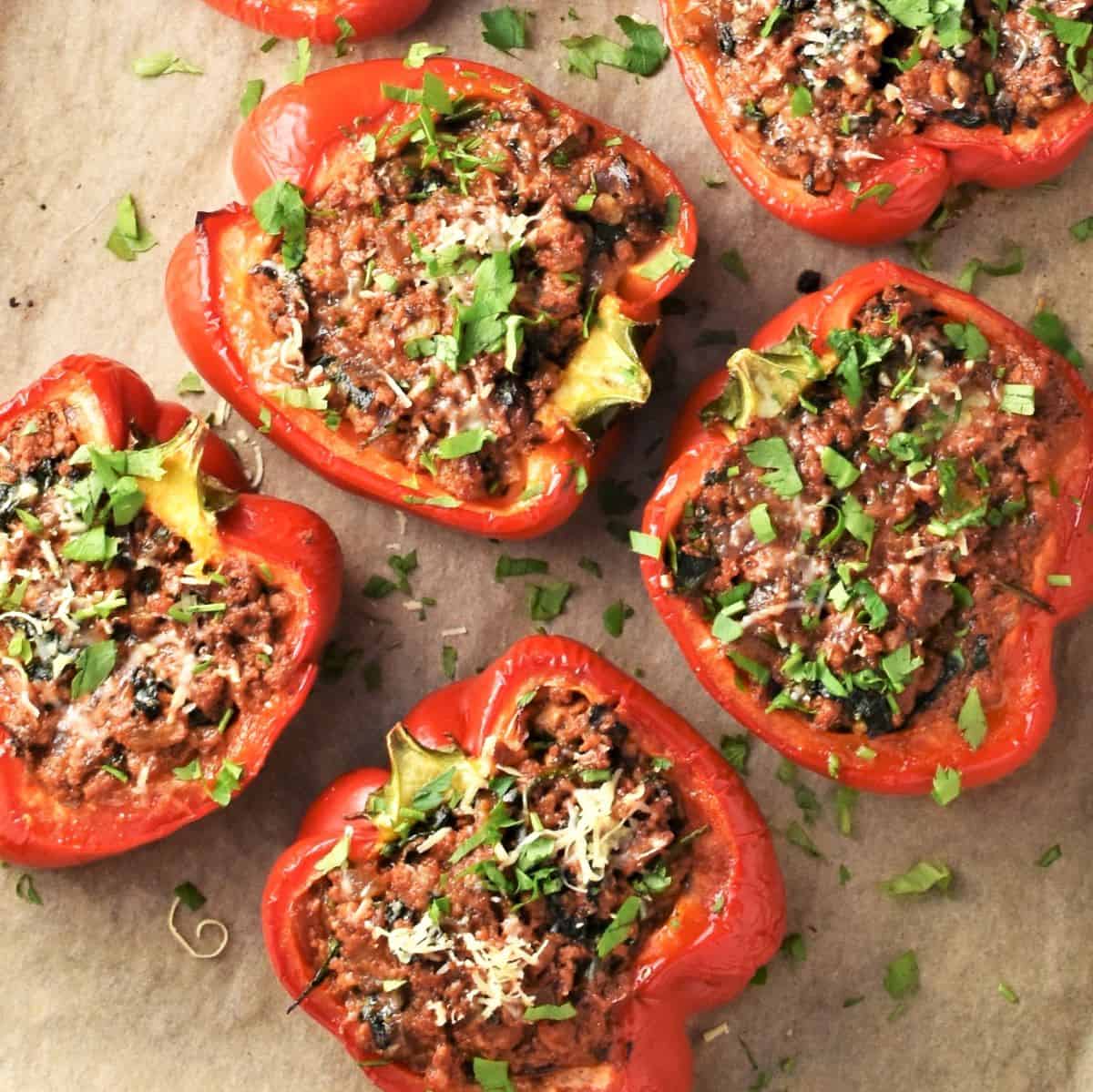 Top down view of stuffed peppers without rice on parchment.