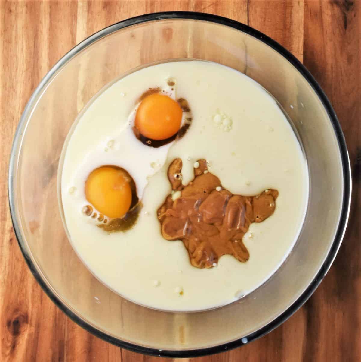 2 eggs, milk and peanut butter in mixing bowl.