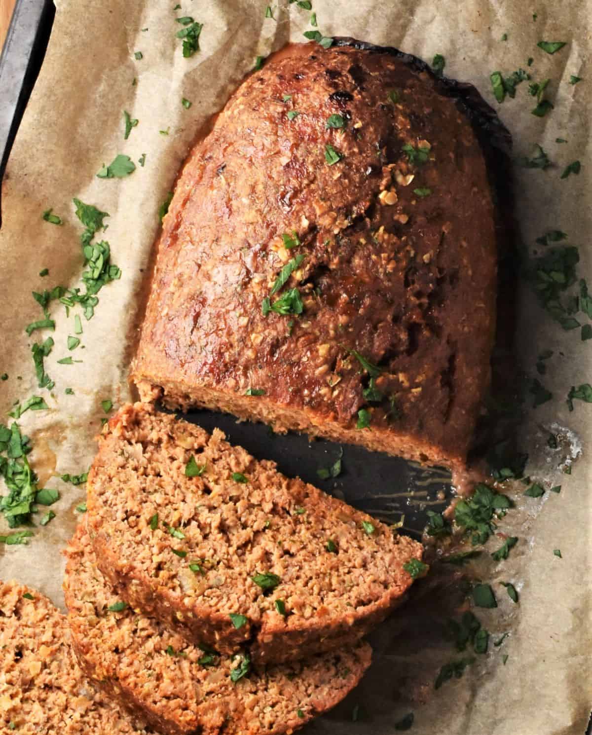 Top down view of sliced turkey meatloaf on parchment.