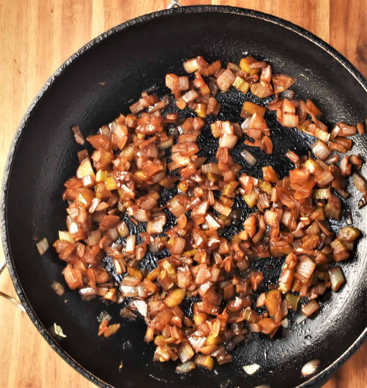 Frying onion with soy sauce in large pan.