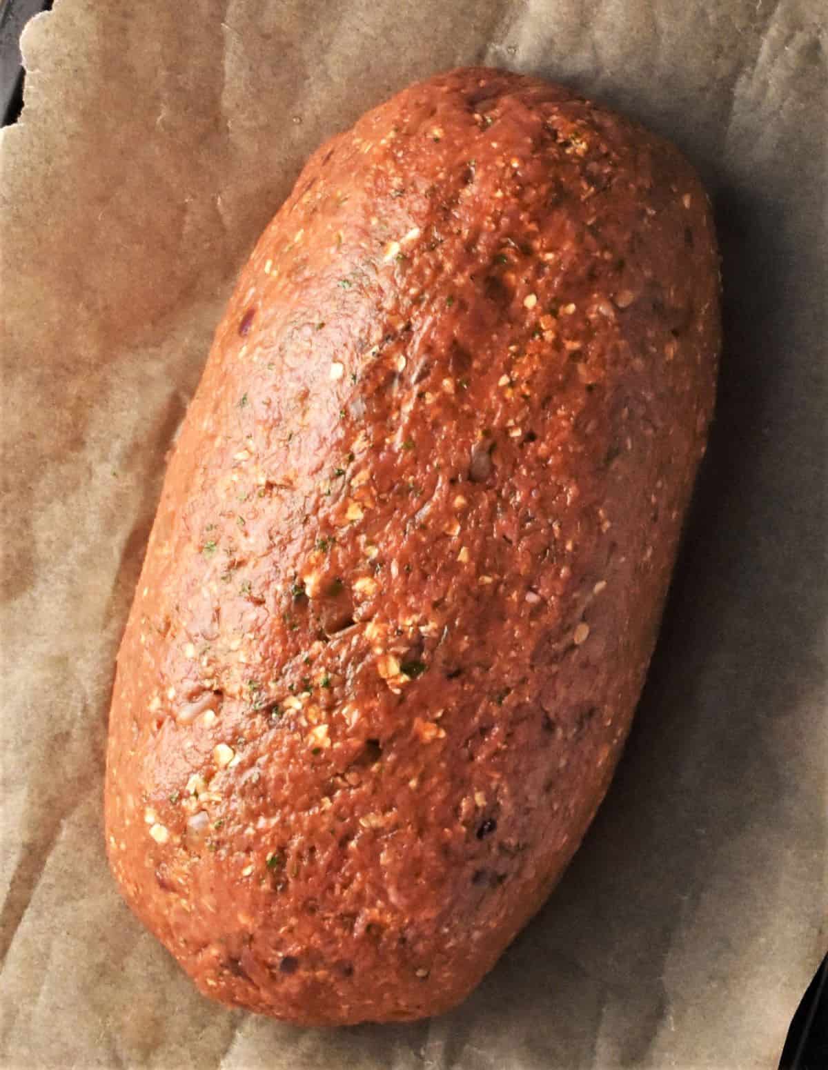 Free-form meatloaf with oatmeal on top of parchment. 