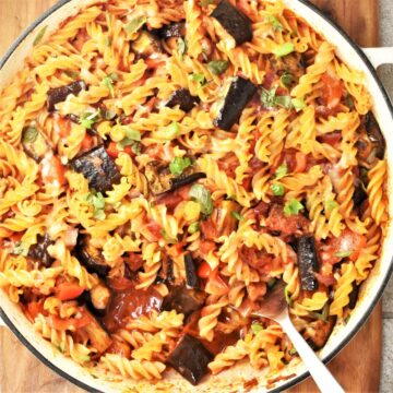 Top down view of eggplant pasta bake in large round dish with spoon.