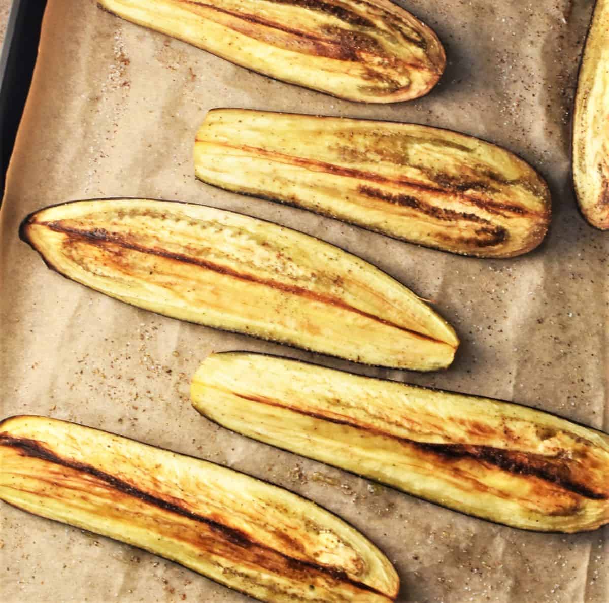 Strips of roasted eggplant on parchment.