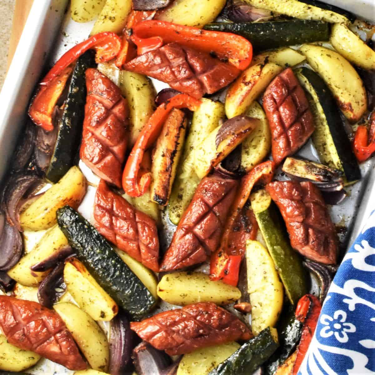 Top down view of baked kielbasa and vegetables.