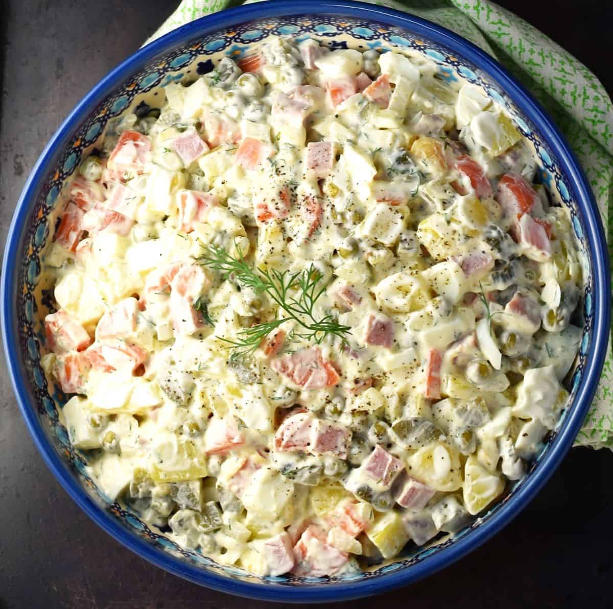 Top down view of Russian Olivier salad in blue bowl.